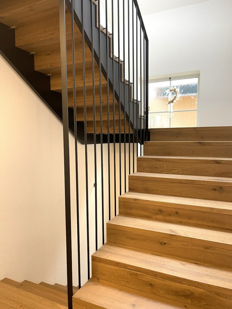 moderne aufgesattelte Treppe in Eiche mit Zwischenpodest und Stahlgeländer