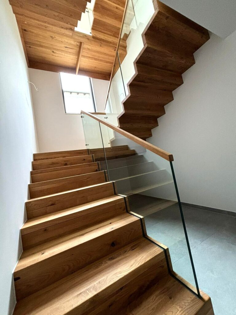 Faltwerktreppe aus Holz mit Zwischenpodest und Glas-Geländer